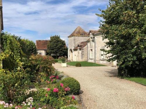 an old stone house with a garden and flowers at Maison de charme avec jardin clos près des vignobles - FR-1-381-262 in Parçay-sur-Vienne
