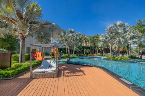 a swimming pool with a playground and palm trees at Wyndham Grand KN Paradise Cam Ranh in Cam Ranh