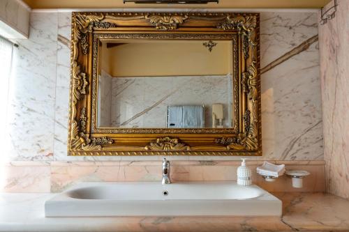 a bathroom with a mirror and a sink at Ha'Seuda Ha'Achrona Suites in Amirim