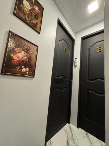 a room with two black doors and paintings on the wall at Unique Vibes Staycation in Punta