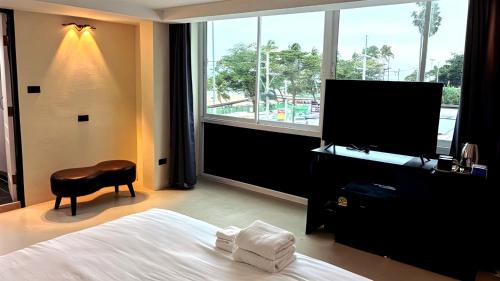 a hotel room with a bed and a flat screen tv at VS Beach Front in Jomtien Beach