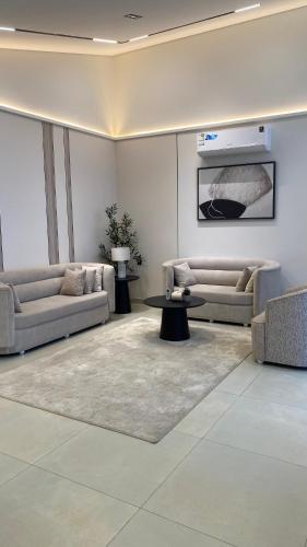a living room with two couches and a table at شفق in Al Shafa