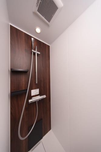 a bathroom with a shower with a cross on the wall at クリスタルヴィラ南城 in Azama