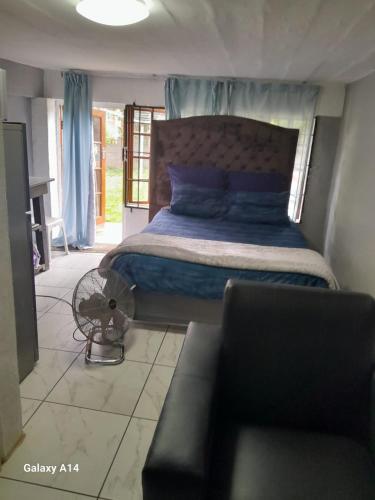 a bedroom with a bed and a couch at PMB Backpackers Lodge in Pietermaritzburg