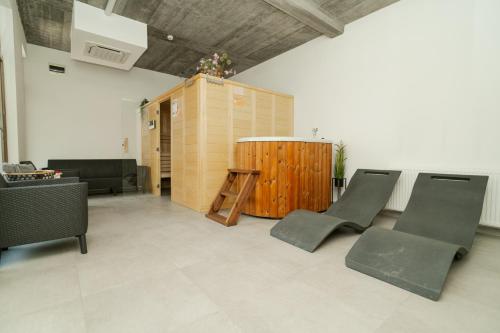 a living room with chairs and a wooden barrel at Niki Apart Pension in Gheorgheni
