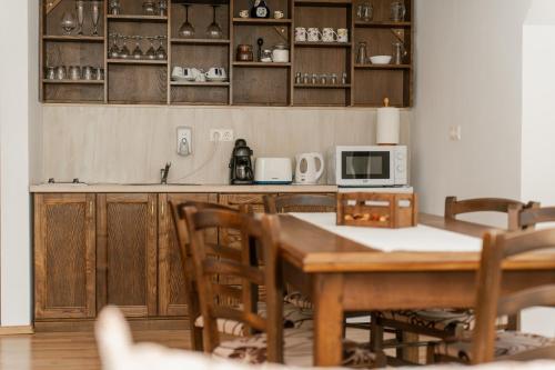 a kitchen with a table with chairs and a microwave at Niki Apart Pension in Gheorgheni