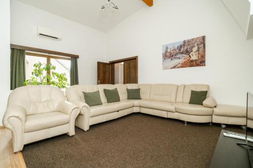 a living room with two white couches and a couch at Niki Apart Pension in Gheorgheni
