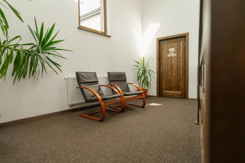 two chairs sitting in a room with a door at Niki Apart Pension in Gheorgheni