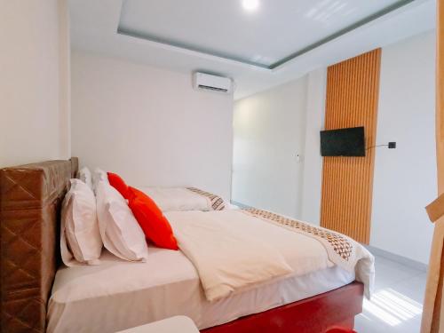 a bedroom with a bed with red and white pillows at Noah Hotel Silangit in Siborongborong