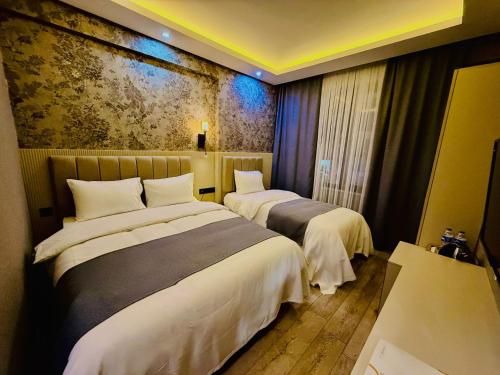 a hotel room with two beds and a painting on the wall at Royal Sevens Otel in Ipekyolu