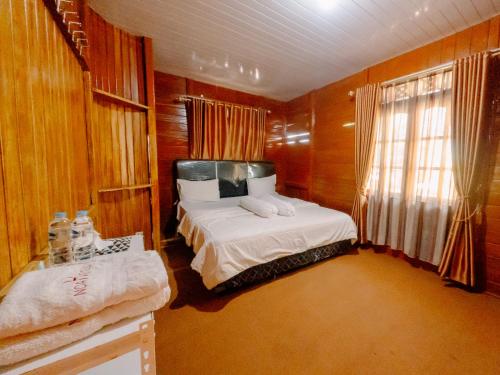 a small bedroom with a bed and a window at Noah Hotel Silangit in Siborongborong