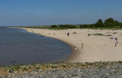 a group of people on a beach near the water at Hübsches Haus in Emden