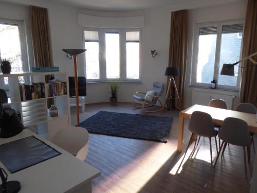 a living room with a table and chairs and windows at Bright & friendly flat in downtown Duisburg - "Miner Mates Home" from revierquartier boutique apartments in Duisburg