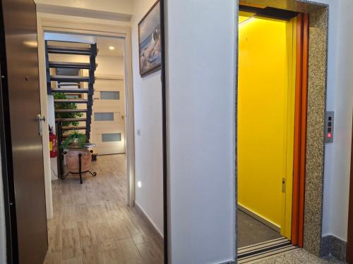 a hallway with a yellow door and a staircase at B&B Brezza Marina in Roccalumera