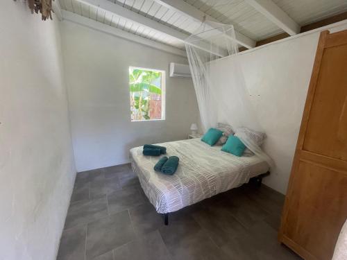 a bedroom with a bed with green pillows on it at Creole Paradise beach wifi in Terre-de-Haut