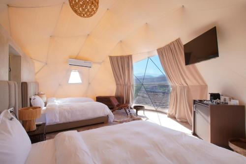 a bedroom with two beds and a large window at The Ranch Camp in El Karia