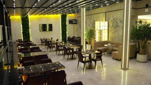 a restaurant with tables and chairs in a room at Royal Sevens Otel in Ipekyolu