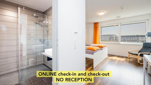 an apartment bathroom with a shower and a bed and a sink at Anstatthotel Schafisheim - app self-check-in in Schafisheim