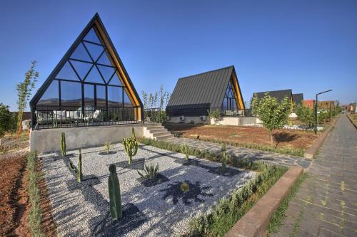 a building with a pyramid shaped roof with cactus at The Ranch Camp in El Karia