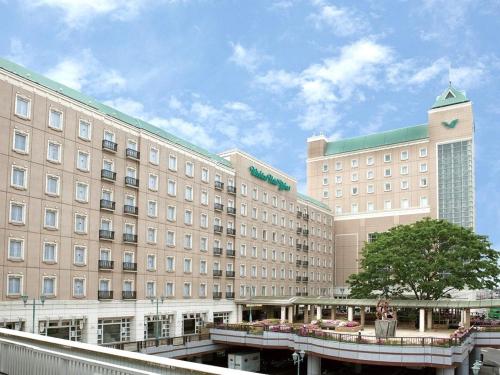 Un gran edificio con un puente delante. en Wishton Hotel Yukari, en Sakura