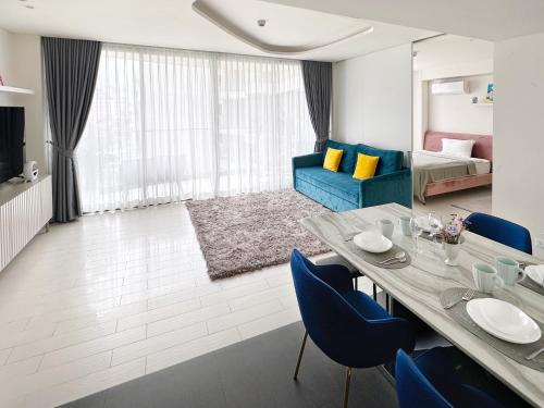 a living room with a dining table and blue chairs at Veranda Residence condo Hua Hin 3 BR in Hua Hin