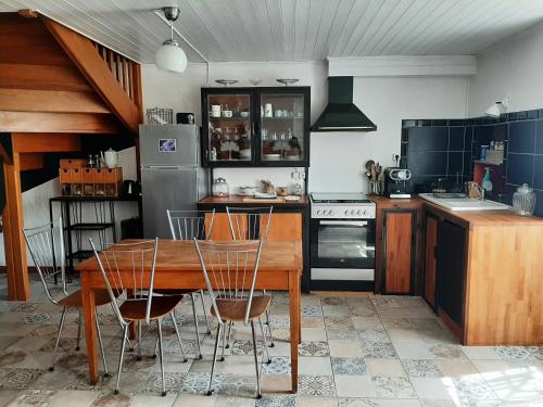 a kitchen with a wooden table and chairs at Charmante maison in Cugand