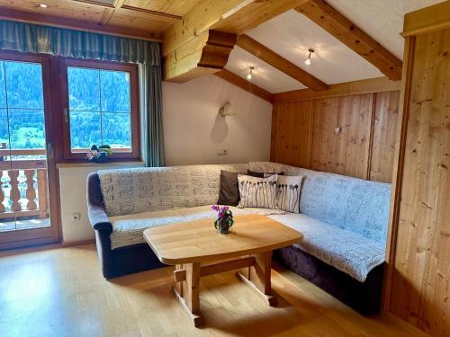 a living room with a couch and a table at Ferienwohnung Oberstallberg in Bramberg am Wildkogel