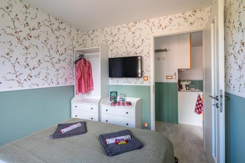 a small bedroom with a bed and a kitchen at Balatonic Orange in Zamárdi