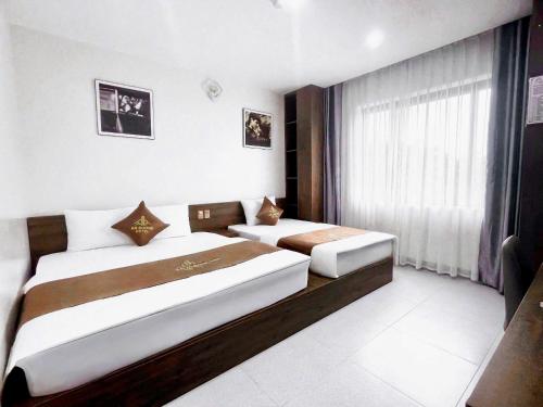 a hotel room with two beds and a window at An Dương Hotel in Lạng Sơn