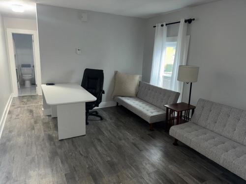 a living room with a couch and a desk and a table at Downtown Willoughby historical district Gem 4 in Willoughby