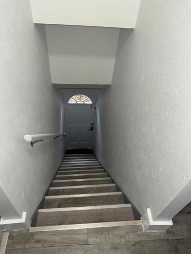 a hallway with stairs with a door and a window at Downtown Willoughby historical district Gem 4 in Willoughby