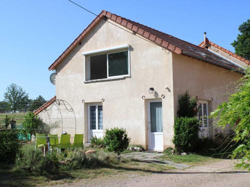 a house with green chairs in front of it at Gîte familial avec terrasse à la ferme, proche Montluçon, idéal pour 4 pers, draps et serviettes inclus - FR-1-489-431 in Sauvagny
