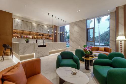 a living room with green chairs and a bar at 西双版纳熙源国际酒店 in Jinghong