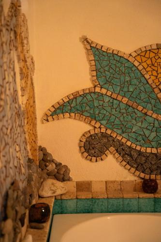 a bathroom with a fish mosaic on the wall at Hotel San Valentino Terme in Ischia