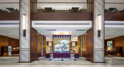 a lobby with a large aquarium in the middle at 西双版纳熙源国际酒店 in Jinghong