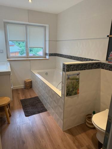 a bathroom with a tub and a toilet in it at Chalet Belleville in Béranger