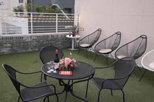 a table and chairs with a bottle of wine and flowers at 호텔 인썸니아 Hotel Insomnia 失眠酒店 in Daegu