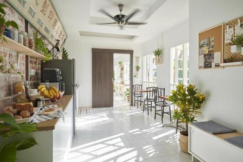 a kitchen with a counter and chairs in a room at Sleepy Nomad Hostel in Melaka
