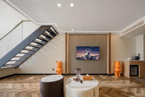 a living room with a staircase and a table and chairs at Ouchen International Sky River Hotel (Monument to the people's Liberation Pedestrian Street Store, Chongqing) in Chongqing