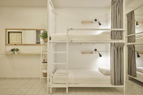 a room with two bunk beds and a mirror at Sleepy Nomad Hostel in Melaka