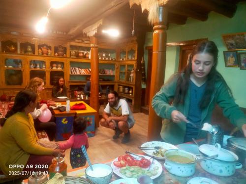 a group of people standing around a table with food at Old Likir Traditional Farm Stay in Leh