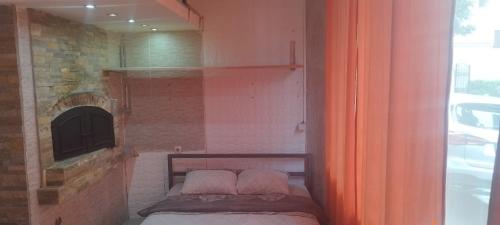 ein kleines Bett in einem Zimmer mit Kamin in der Unterkunft Small apartment with private bathrooms STRONG INTERNET in Belgrad