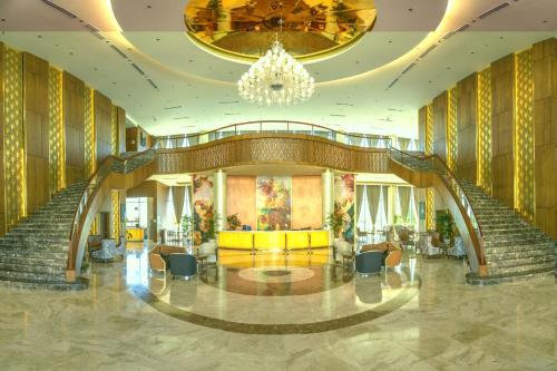 a lobby with stairs and a chandelier at Wyndham Grand KN Paradise Cam Ranh in Cam Ranh