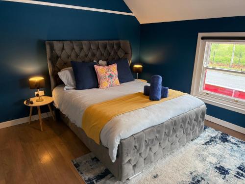 a bedroom with a large bed with blue walls at Crown and Shamrock Inn in Hyde Park