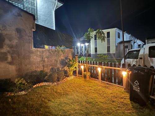 a backyard at night with lights on a fence at Unique Vibes Staycation in Punta