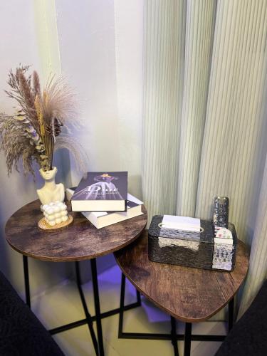 two wooden tables with books and a vase on them at Unique Vibes Staycation in Punta