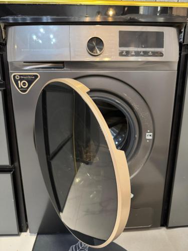 a washing machine with a round mirror on it at Unique Vibes Staycation in Punta