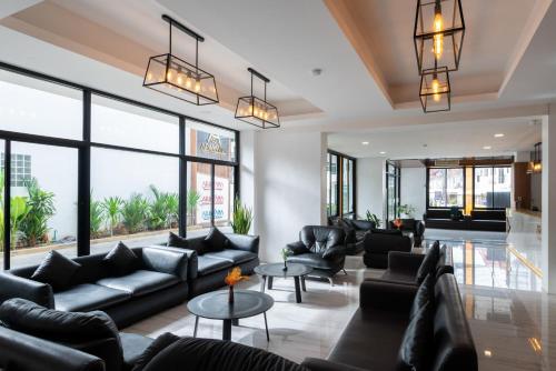 a lobby with black couches and tables and windows at Arawana Regency North Pattaya in Pattaya Central