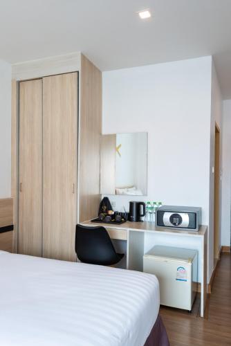 a bedroom with a bed and a desk with a microwave at Arawana Regency North Pattaya in Pattaya Central