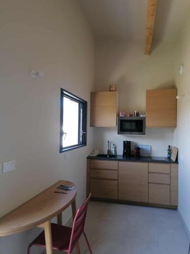 a kitchen with a table and a table and a window at Gite neuf avec accès sauna, bain a remous in Crespian